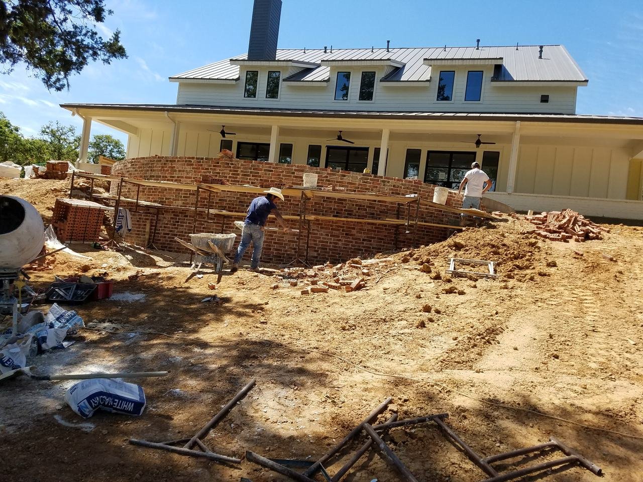 Brick retaining wall being built behind a home near Fayetteville, TX