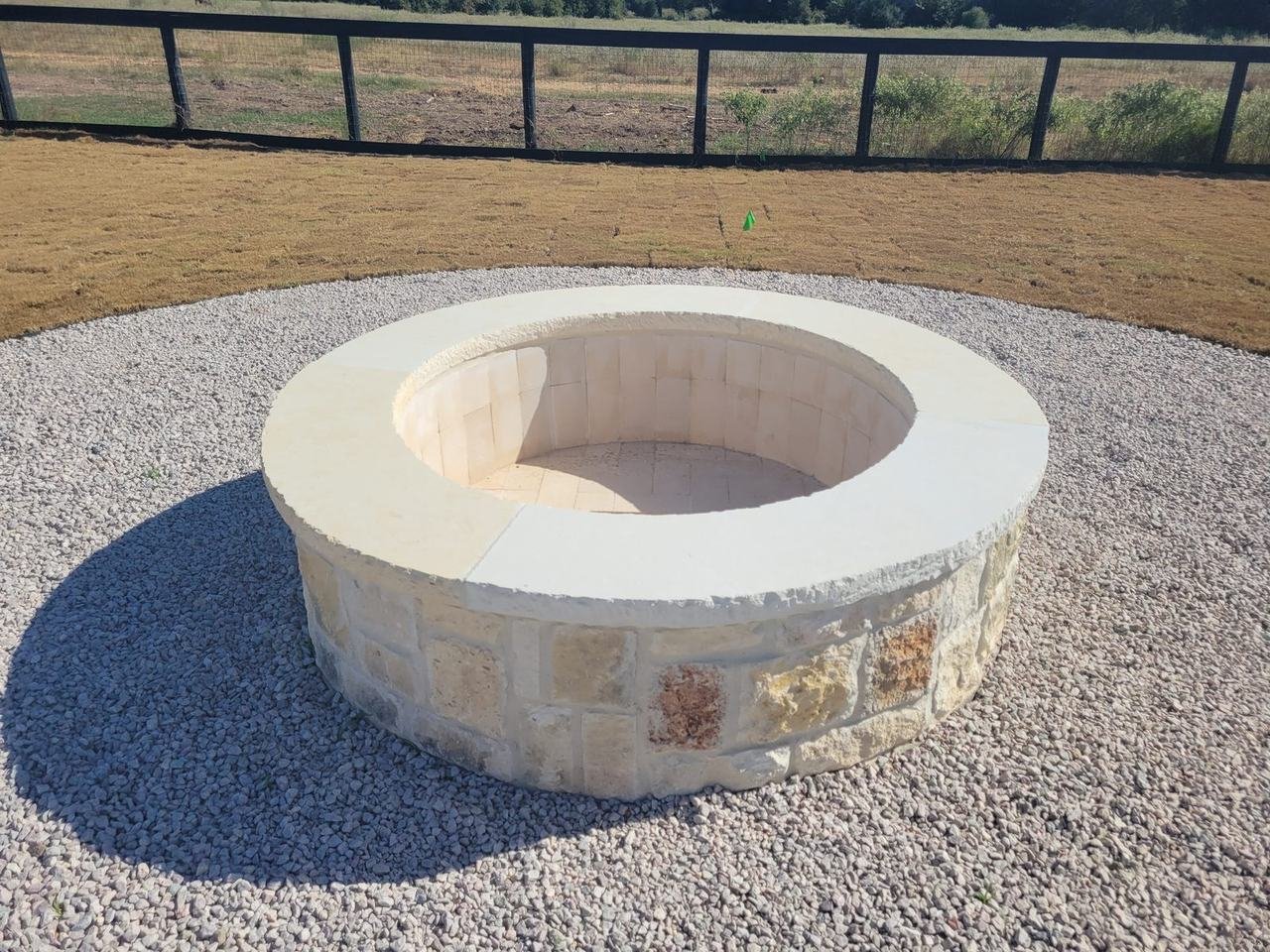 Round stone fire pit in a gravel circle near Fayetteville, TX