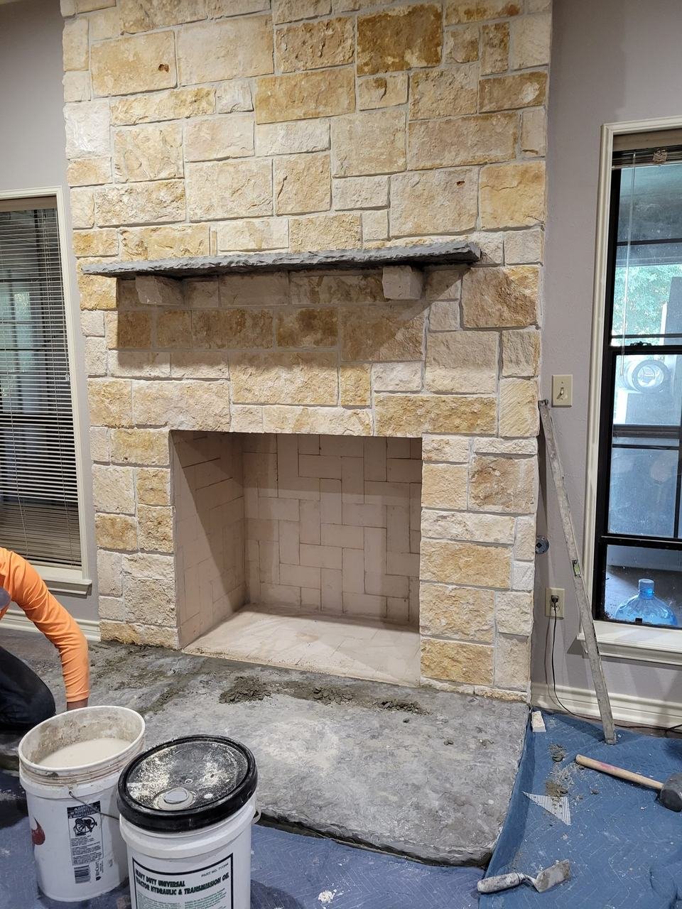 Cut stone fireplace with a wood mantel in a College Station, TX home