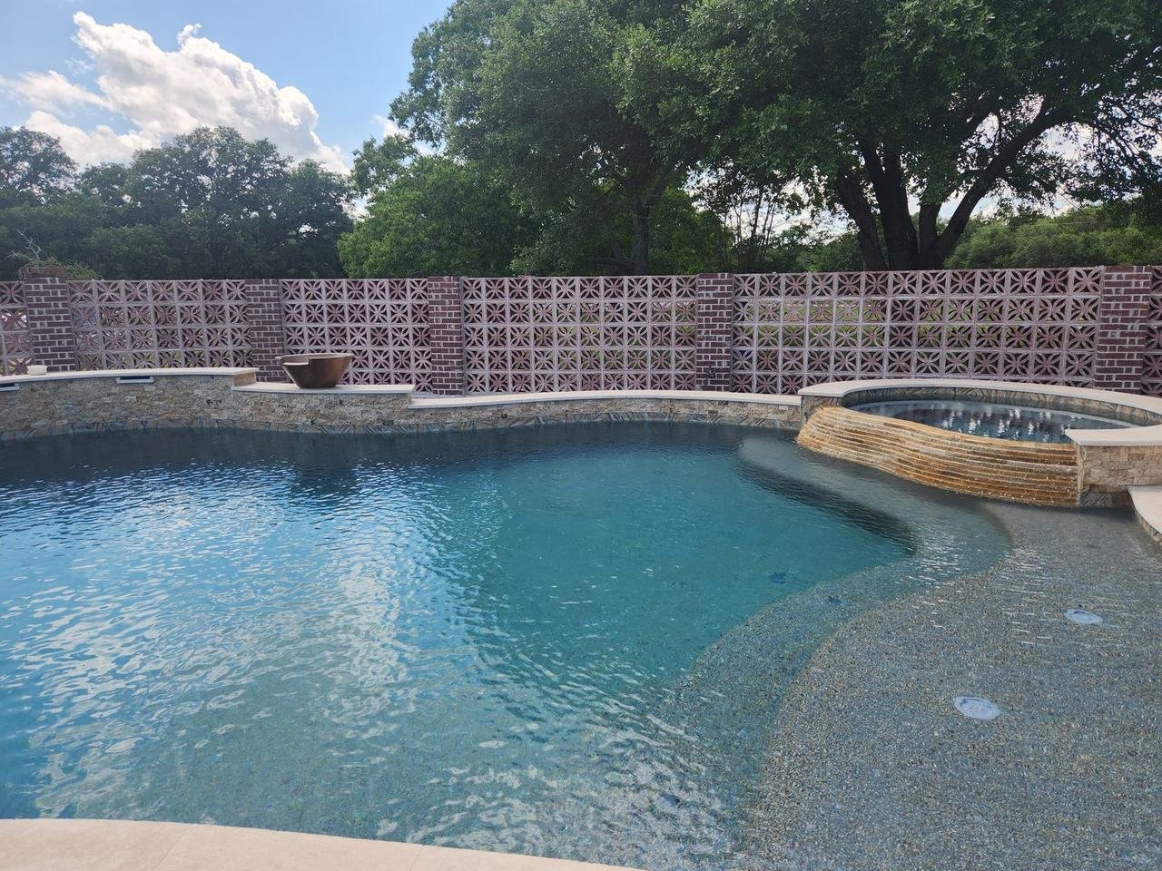Decorative brick wall behind a pool in Bellville, TX