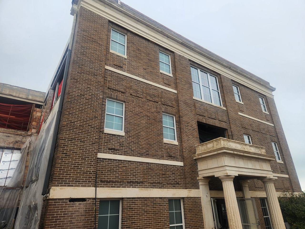 Three-story brick building with scaffolding in Cameron, TX