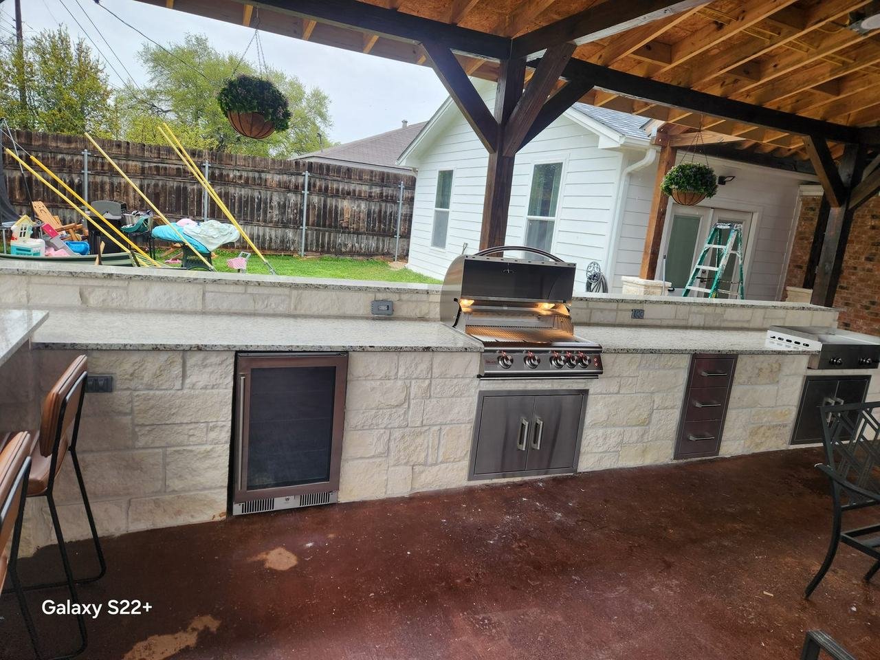 Outdoor kitchen with built-in grill and stone cladding in College Station, TX