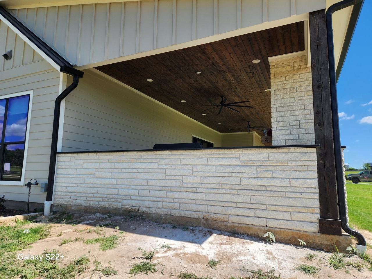 Stone-clad covered patio in Bellville, TX