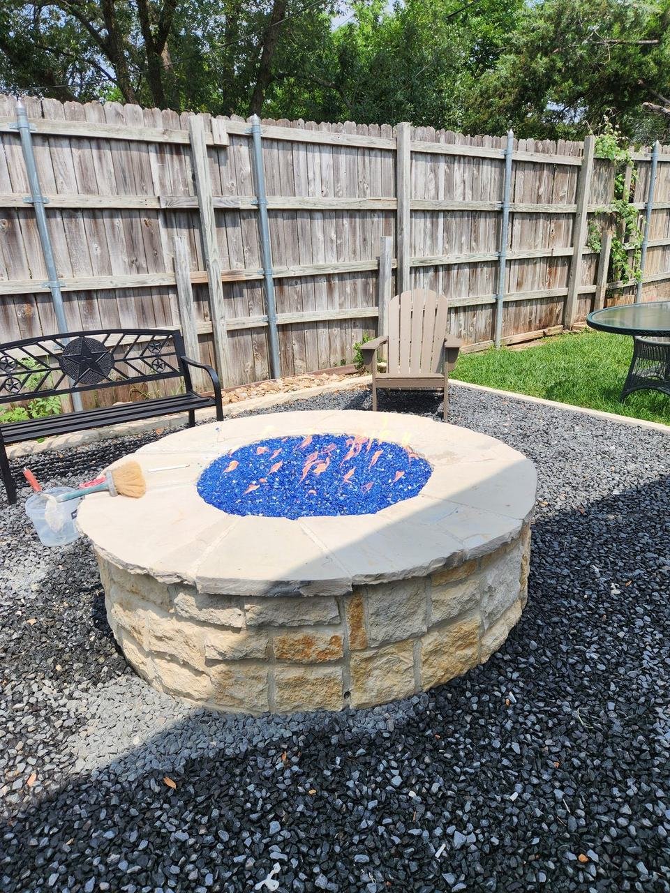 Stone fire pit table in a gravel backyard in College Station, TX