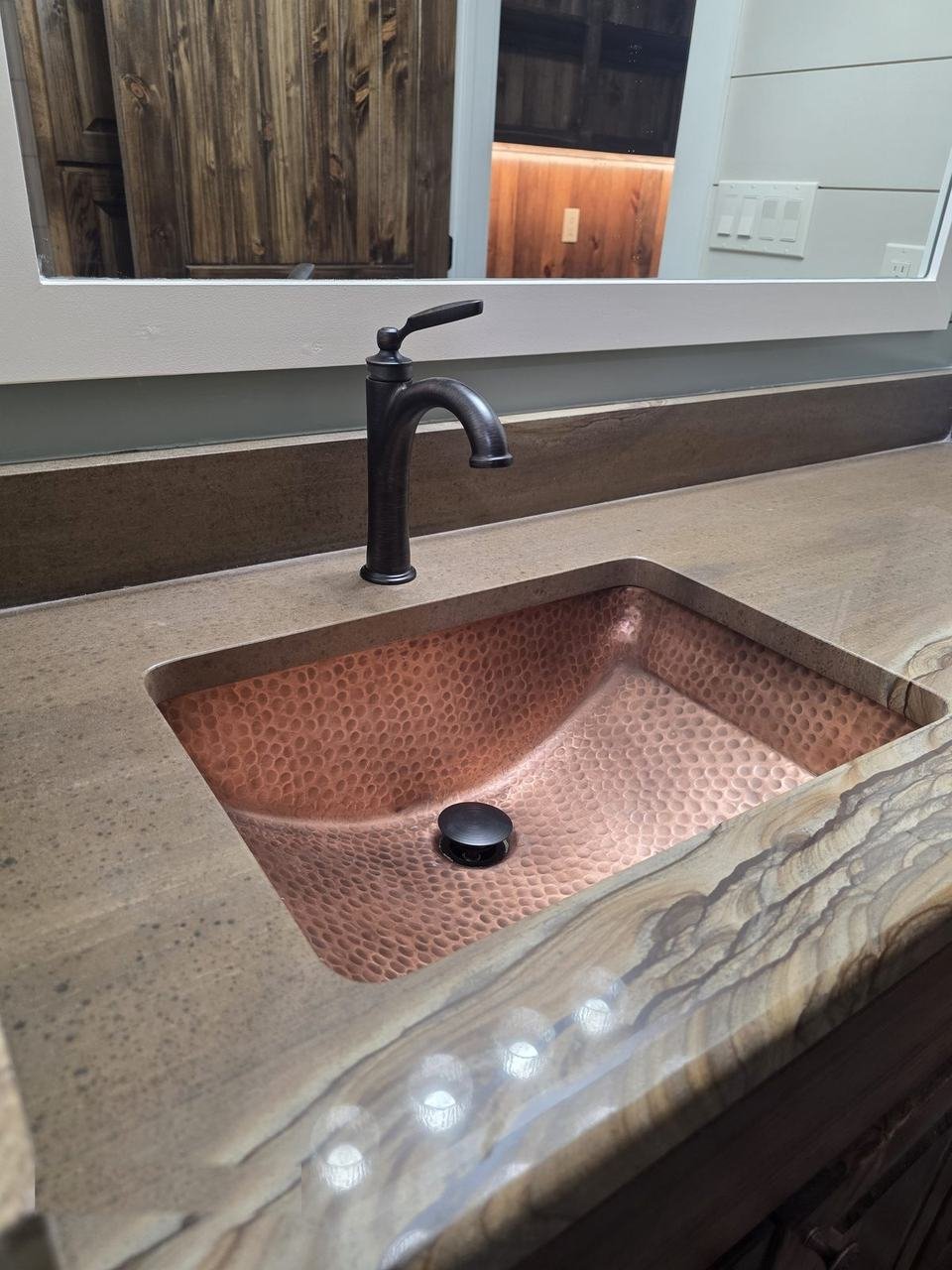 Natural stone vanity top with copper sink in a Giddings, TX bathroom