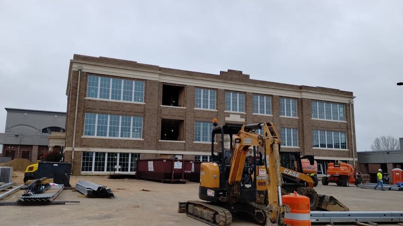 Brick building with an excavator on site in Cameron, TX